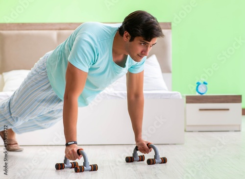 Young man in pajamas doing morning exercises