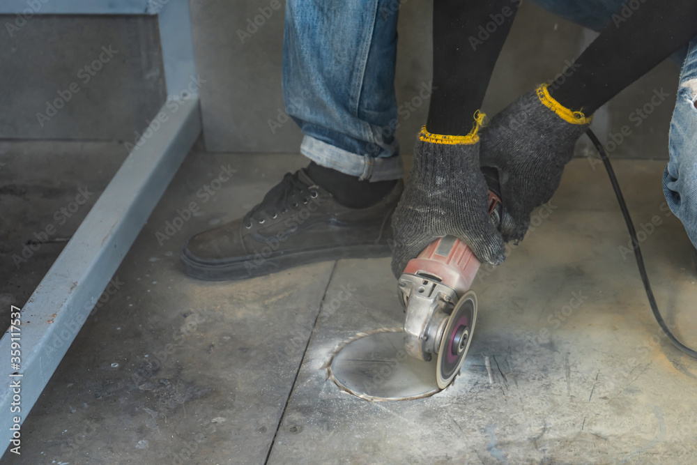 Construction worker is cutting the floor by medium blade machine to circle hold shape with a lot of dust around it for install closet with. Construction worker is cutting the floor by medium blade machine to circle hold shape with a lot of dust around it for install closet with.