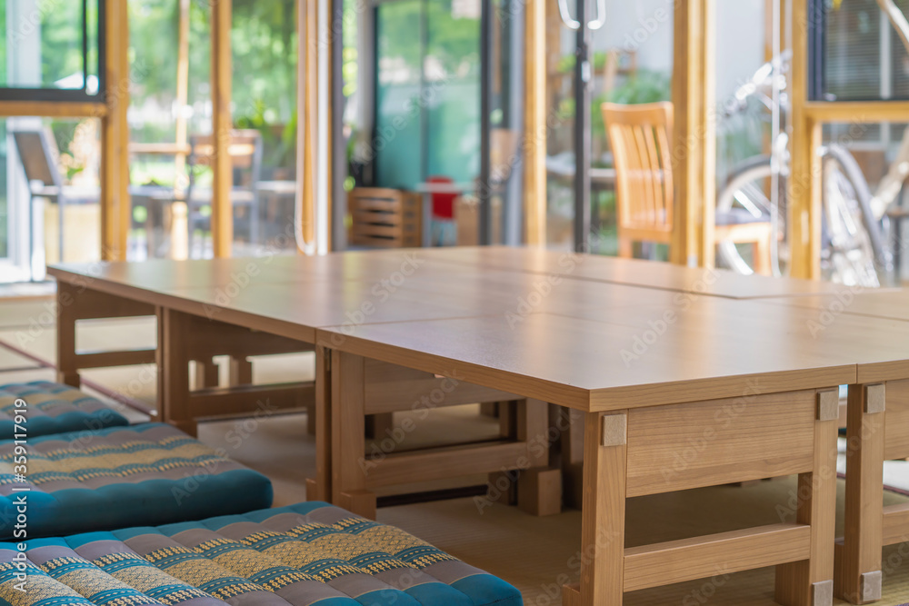 little small wood table are arranged for long table Japanese room style on the mat in glass room that prepare for lunch time. little small wood table are arranged for long table Japanese room style on the mat in glass room that prepare for lunch time.