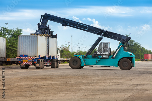 Crane lifter handling container box loading to truck in import export logistic zone