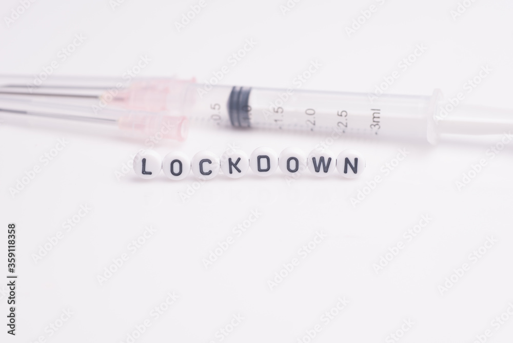 The word lock down with medical syringe,isolated over bright white background The word lock down with medical syringe,isolated over bright white background
