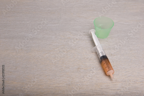 A syringe isolated over grey wooden background