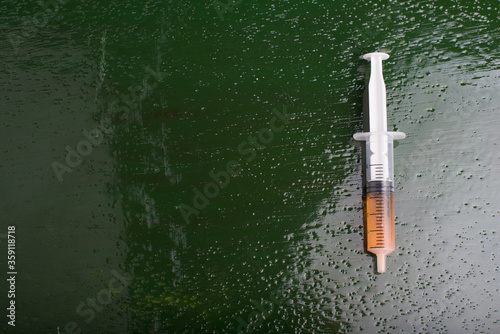 A syringe isolated over green wooden back ground,high angle shot
