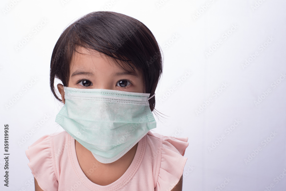 A female child wearing oversize medical face mask,isolated over white A female child wearing oversize medical face mask,isolated over white