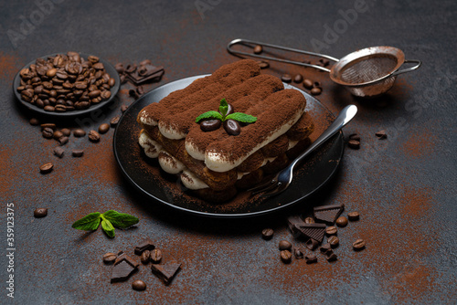 Classic tiramisu dessert on ceramic plate on concrete background