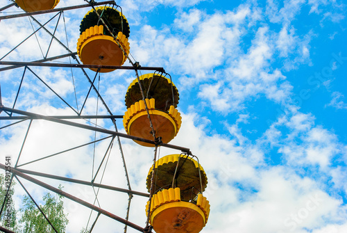 Observation wheel carousel with yellow cabins in the former musement park in Pripyat, a ghost town in northern Ukraine, evacuated the day after the Chernobyl disaster on April 26, 1986 photo