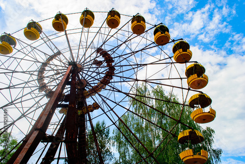 Observation wheel carousel with yellow cabins in the former musement park in Pripyat, a ghost town in northern Ukraine, evacuated the day after the Chernobyl disaster on April 26, 1986 photo