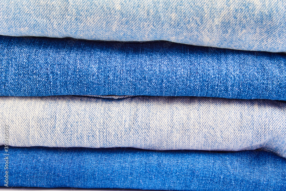 a stack of denim clothing in close-up. textured background of blue color