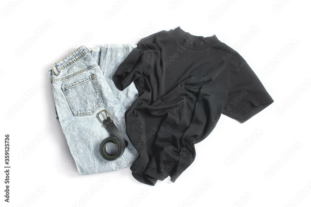 denim pants, a black tank top and a leather belt on a white background. online shopping concept. simple flat lay, top view denim pants, a black tank top and a leather belt on a white background. online shopping concept. simple flat lay, top view