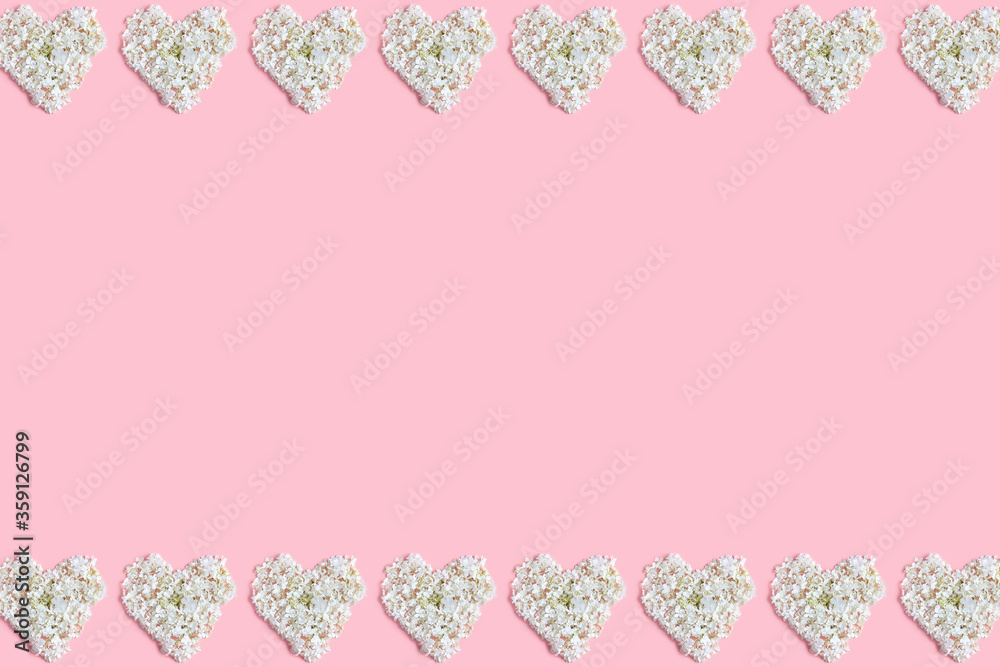 frame made hearts of white hydrangea flowers on a pink background. flat lay, top view, space for a text