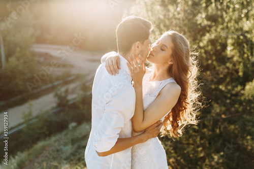 A happy young couple about to kiss. Couple walks in nature at sunset.