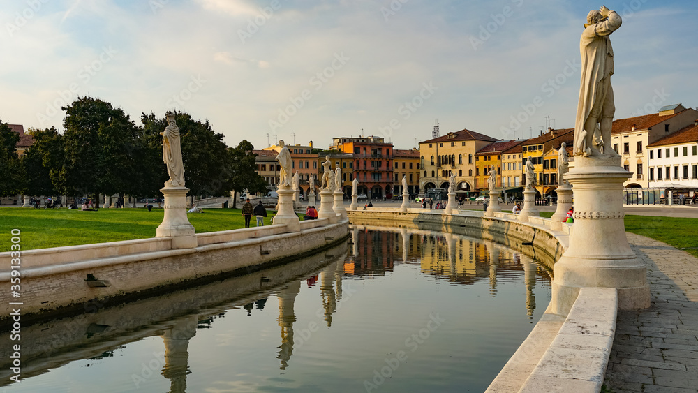 PADUA, ITALY - OCTOBER, 2017: Piazza Prato della Valle on Santa Giustina abbey. Prato della Valle elliptical square, surrounded by a small canal and bordered by two rings of statues.