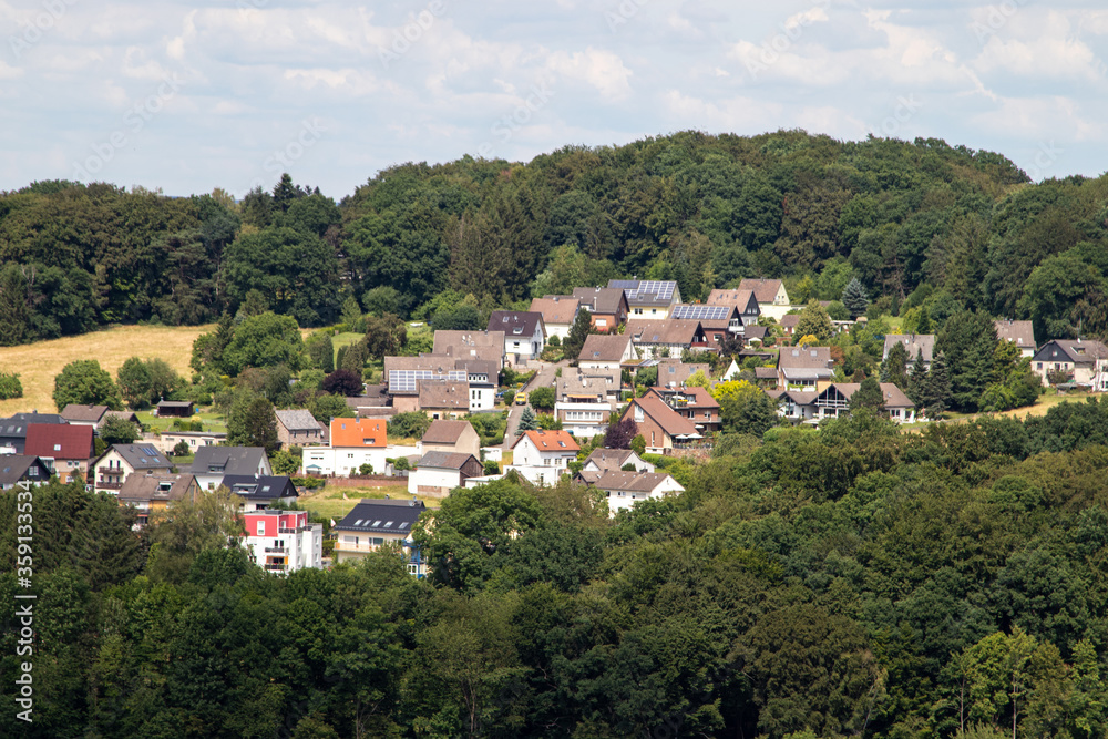 view over a village, rooftops, hills in the background view over a village, rooftops, hills in the background