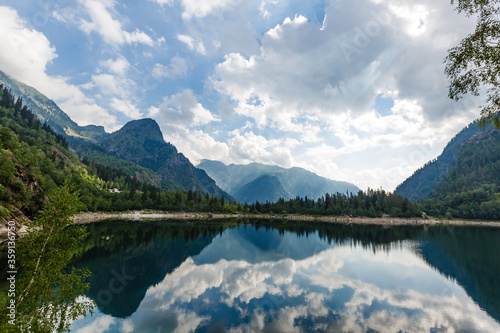 alpine high mountain lake, coniferous woods are reflected in the water, Antrona valley Campliccioli lake, Italy Piedmont