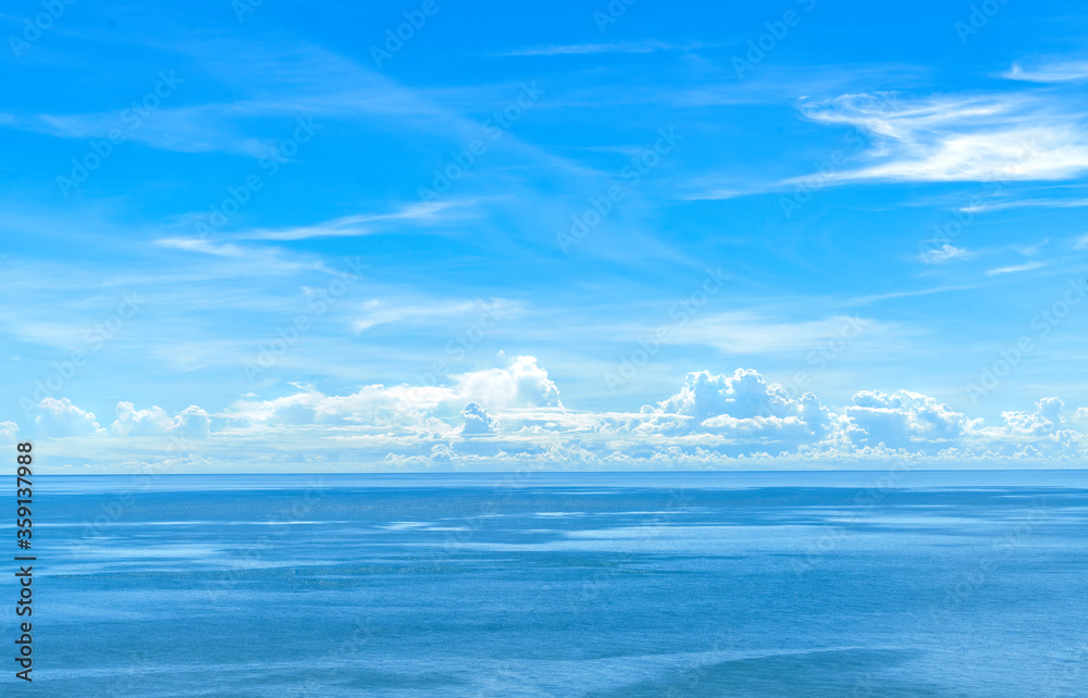 Beautiful vast blue sky and ocean, sparkling water surface of ocean, white and bright cloudscape. Beautiful blue colour of nature. Wide image from high view position.