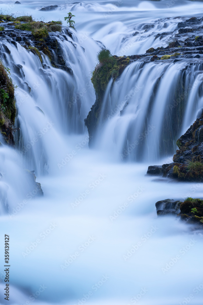 Obraz premium Beautiful and powerful of white streaming at Bruarfoss waterfall and black lava rock around waterfall in evening,Summer,Iceland. 