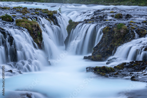Beautiful and powerful of white streaming at Bruarfoss waterfall and black lava rock around waterfall in evening,Summer,Iceland. 