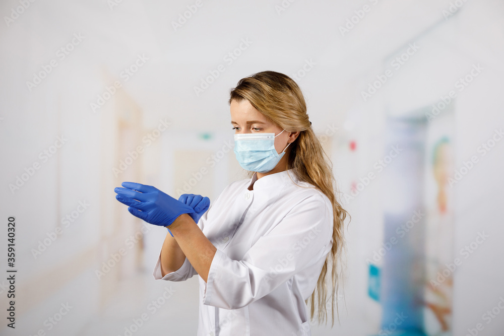 Φωτογραφία Doctor woman surgeon specialist in sterile clothing putting on surgical gloves