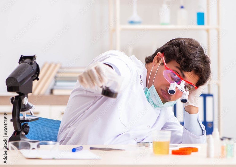 Young handsome chemist working in the lab Young handsome chemist working in the lab