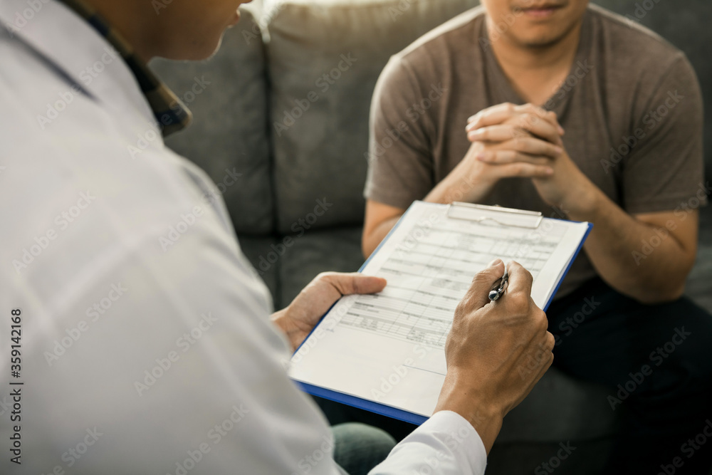 Fototapeta premium Asian doctor is examining the abnormal items of the body and diagnosing the disease in the paper with the medical report of the patient.