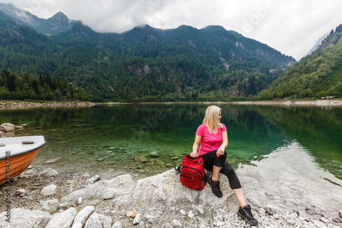 Carefree female tourist relaxing in the forest near the lake