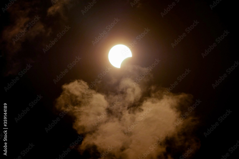 Partial solar eclipse viewed under cloudy skies. Stavropol on 21th June 2020