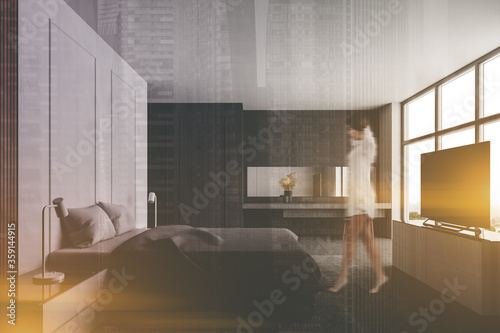 Woman walking in white bedroom with TV