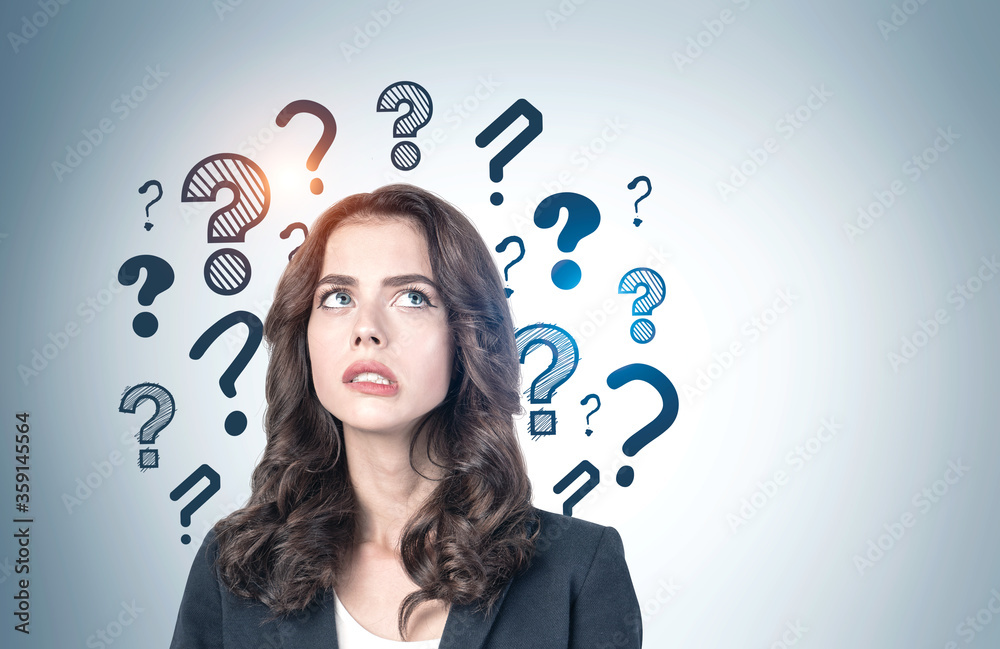 Troubled young businesswoman, question marks Troubled young businesswoman, question marks