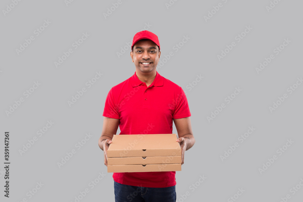 Delivery Man with Three Pizza Box in Hands Isolated. Red Tshirt Indian Delivery Boy. Delivery Man with Three Pizza Box in Hands Isolated. Red Tshirt Indian Delivery Boy.