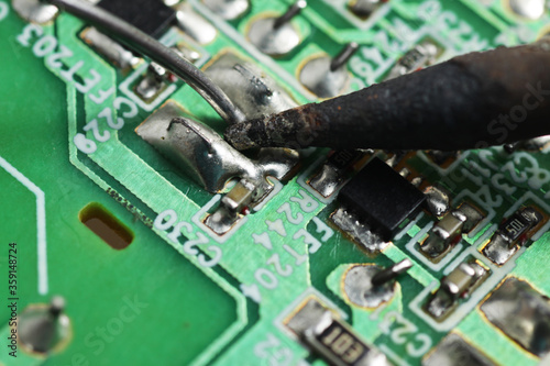 Close up shoot of soldering process SMD / surface mount component on a green Printed Circuit Board