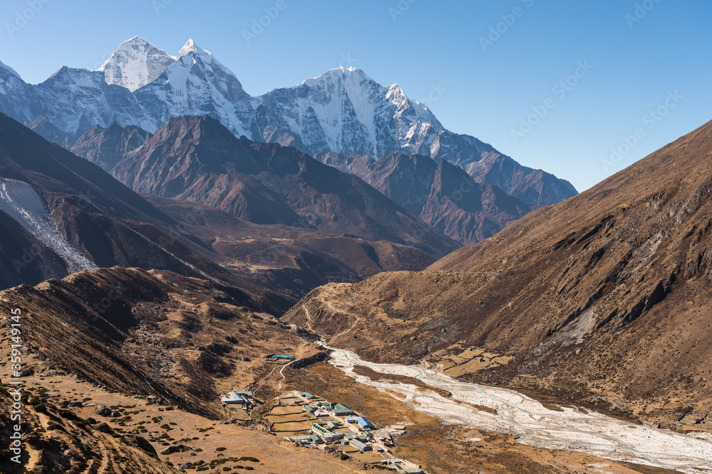 Pheriche village with Kangtega and Thamserku mountain peak behind. A village in Everest base camp trekking route. Himalaya mountains range in Nepal Pheriche village with Kangtega and Thamserku mountain peak behind. A village in Everest base camp trekking route. Himalaya mountains range in Nepal