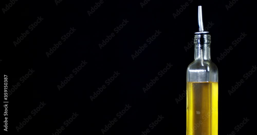Glass bottle with olive oil slowly rotates. Glass bottle with olive oil slowly rotates.