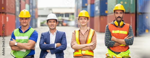 Teamwork engineer technician and foreman and partner wearing safety helmet in cargo container shipping area, worker successful, container background.