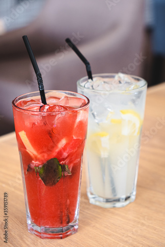 Wallpaper Mural two summer refreshments with ice, lemon, strawberries, mint in tall glasses with a straw on a table in a restaurant. healthy lemonade. out of the house. Torontodigital.ca