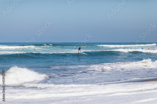 KUTA, BALI, INDONESIA - february, 2020: Kuta beach in Bali. Many beginner surfers in the ocean take lesson. Surfing school.