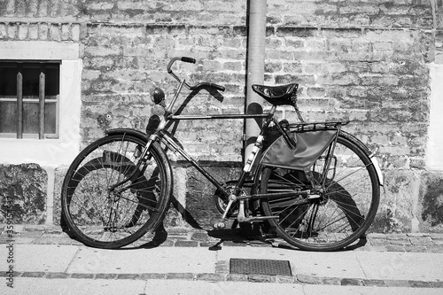 Old bicycle on a brick wall background. Copenhagen. Denmark.Black and white photo. Vehicle. Transport. © vallerato