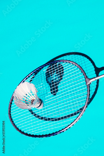 Imagen moderna y colorida de un set de badminton con raquetas y proyectil de plumas blanco