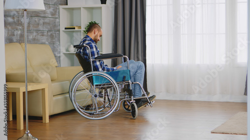 Lonely man in wheelchair with walking disability in living room.