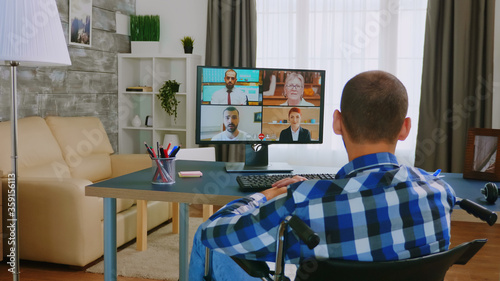 Disabled man in wheelchair during a video call with colleagues.