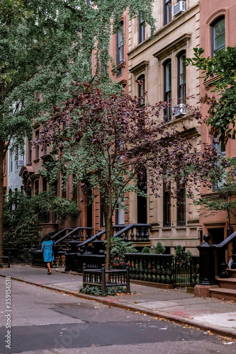 Fototapeta Naklejka Na Ścianę i Meble -  Street in Greenwich Village, Soho district. Beautiful houses and classic luxury apartment building. Entrance doors with stairs and trees. Manhattan, New York