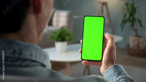 POV View of Man at Phone with Green Screen for Copy Space. Chromakey Mock Up Without Tracking Markers. 20s Boy Watching Video News on Couch Close up. Tap to Click on Centre of Screen