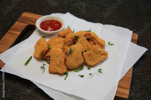 Serve chicken nuggets with vegetables and saur on a white plate photo