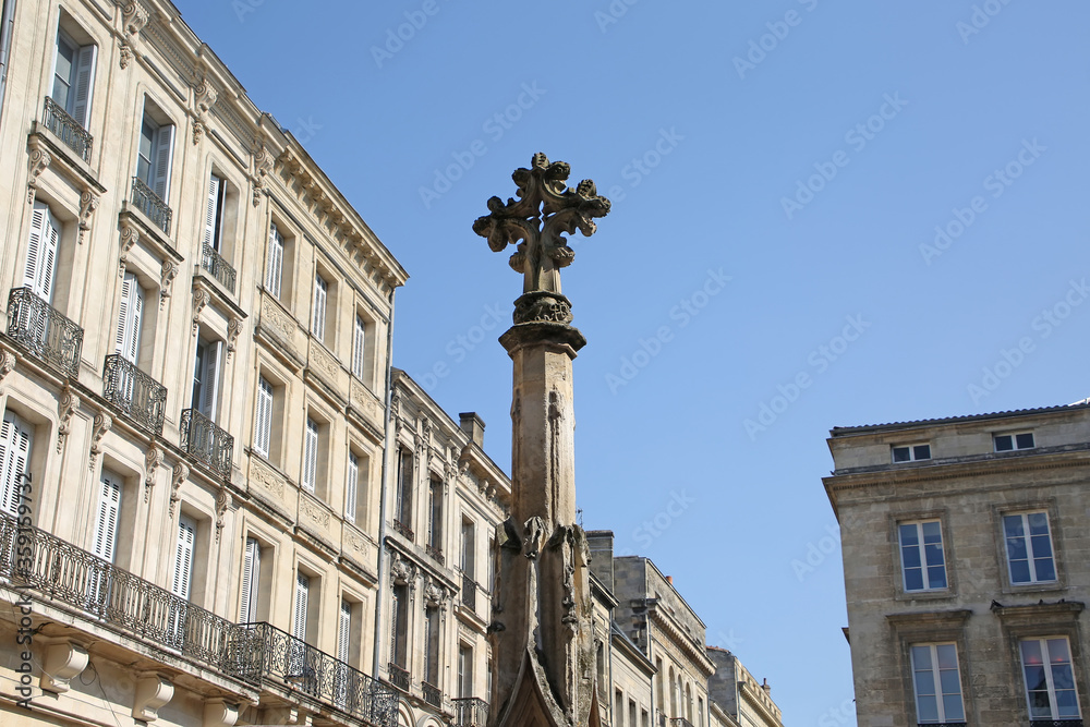 Ancient Cross monument on the Place Saint-Projet square, in the old town with beautiful architecture surrounding it, Bordeaux, France.