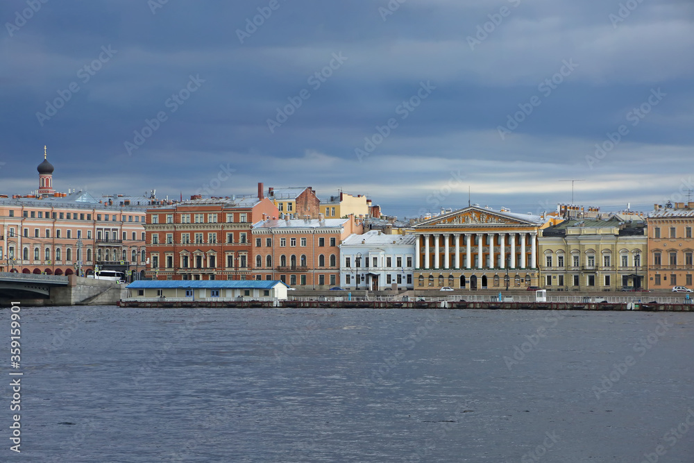 View accross the Neva river, which is one of the main waterways of the city, and historic colurful buildings on the other side, St Petersburg, Russia.