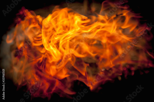 Fire against black background as symbol of hell and eternal pain. Horizontal image.