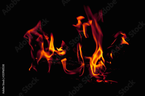 Fire flame against black background as symbol of hell and eternal pain.