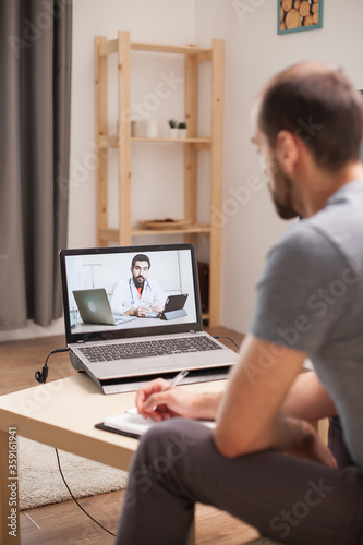Sick man listening his doctor in a video conference during quarantine.