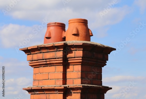 Ceramic chimney pots on the top of a red brick chimney. photo