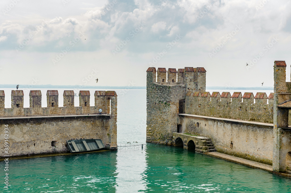It's Wall of the Castello Scaligero di Sirmione (Sirmione Castle), built in XIV century, Lake Garda, Sirmione, Italy It's Wall of the Castello Scaligero di Sirmione (Sirmione Castle), built in XIV century, Lake Garda, Sirmione, Italy
