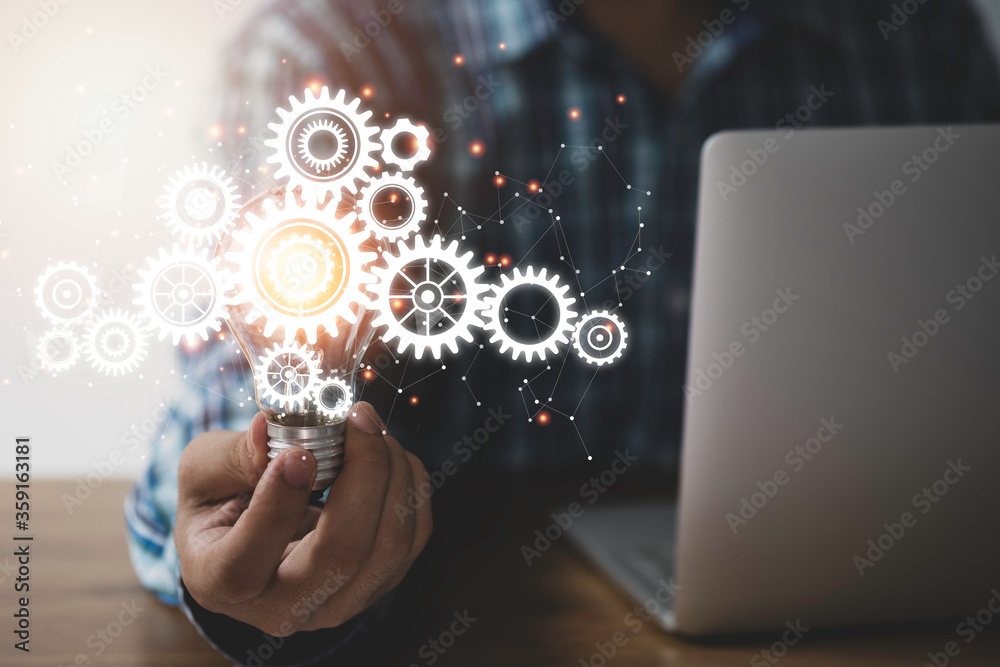 Businessman hand holding lightbulb with cog gears and connection line. Creative thinking idea concept. Businessman hand holding lightbulb with cog gears and connection line. Creative thinking idea concept.
